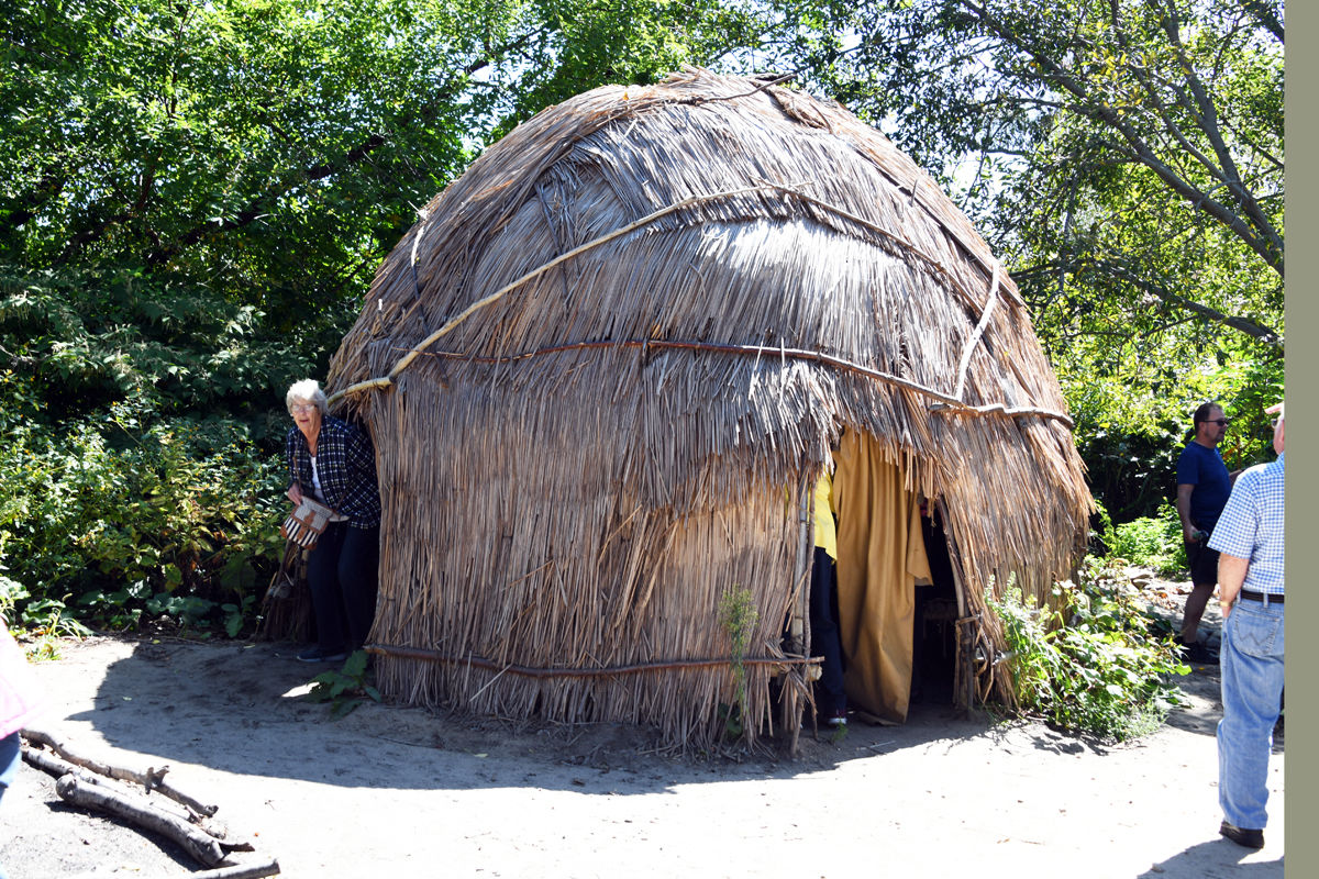 017 Joyce Dose emerges from the Wampanoag hut at the Plimoth Plantation.jpg